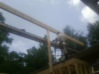 Carpenter setting a ridge beam over a new addition frame — Ice Dam Removal by Roofing Brothers in Allensville