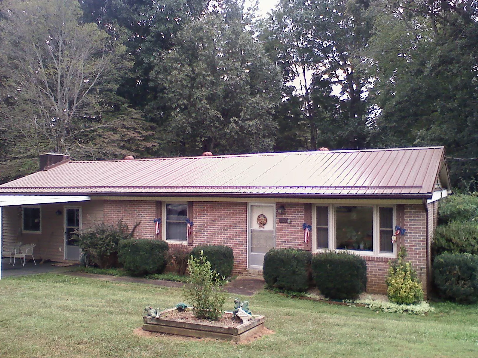 Bronze metal roof on a brick ranch home with a carport in Allensville
